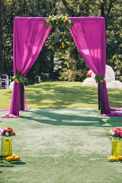 Gyönyörű esküvői boltív. Ív díszített lila ruhával és citrom — Stock Fotó