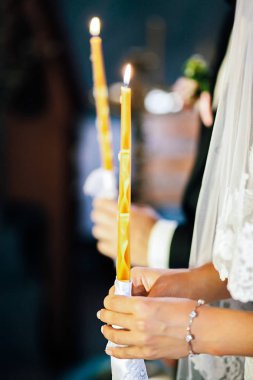 Gelin ve damat yanan mum tutan kilisede