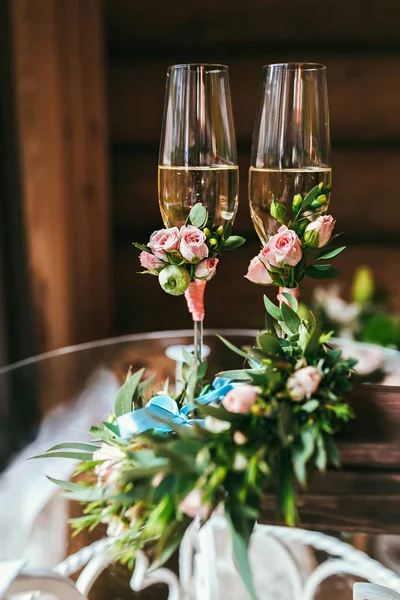 Два бокала шампанского украшены небольшим бутоньером — стоковое фото