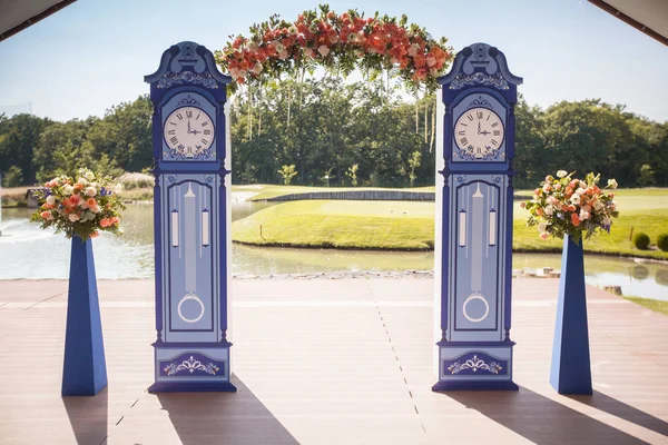 Krásné svatební oblouk. Oblouk jako hodiny broskvový květinovou výzdobou — Stock fotografie