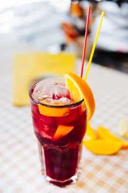 Payet ile kokteyl kırmızı ve turuncu yüksek cam arasına bir şey koy