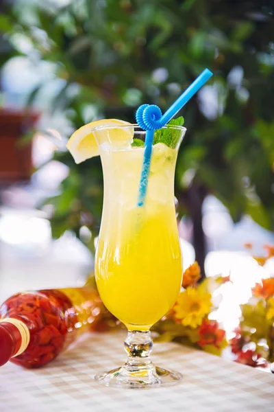 Yellow koktejl s slámy a citrónové klínové ve vysoké sklenici — Stock fotografie