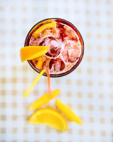 Koktejl s brčka červené a oranžové klín ve vysoké sklenici — Stock fotografie