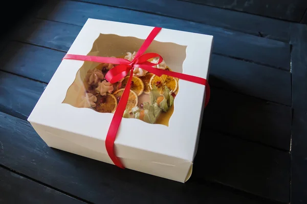 Cake with meringue in box with ribbon