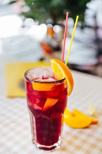 Koktejl s brčka červené a oranžové klín ve vysoké sklenici — Stock fotografie