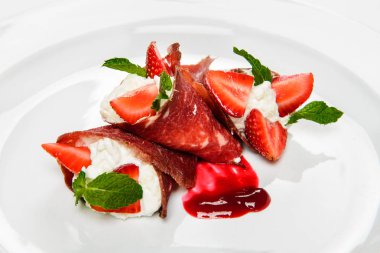 Çilek ve beyaz krem nane ile dilimlenmiş jamon kaplı.