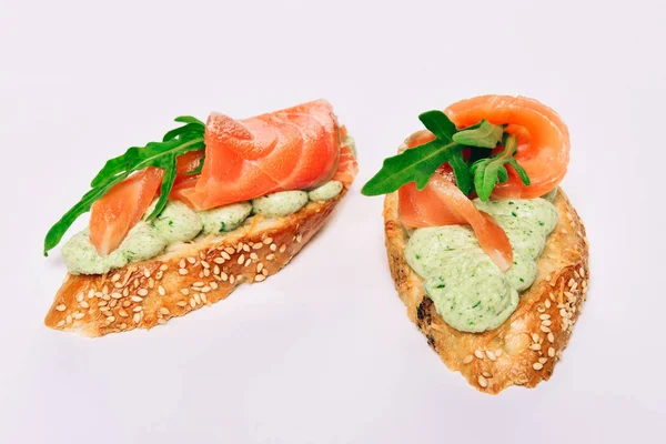 Två bruschettes med ruccola i oxfilé tonfisk och grön sås — Stockfoto