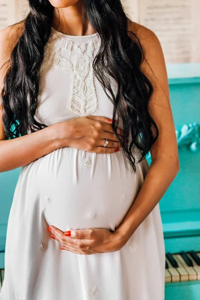 Hermosa mujer embarazada vestida con vestido blanco toca su vientre —  Fotos de Stock