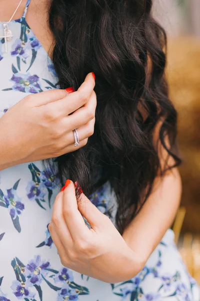 Красива жінка торкається її рук довге, чорне і кучеряве волосся — стокове фото