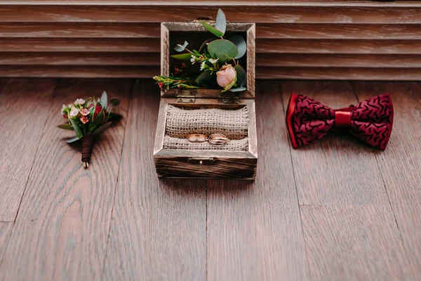 Anelli d'oro nella bella scatola rustica ed eleganti accessori da sposa da uomo sullo sfondo in legno — Foto Stock