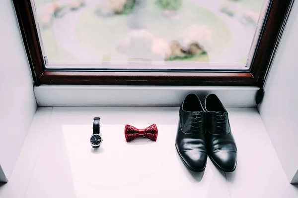 Grooms shoes, bow tie and watch on light window background — Stock Photo, Image