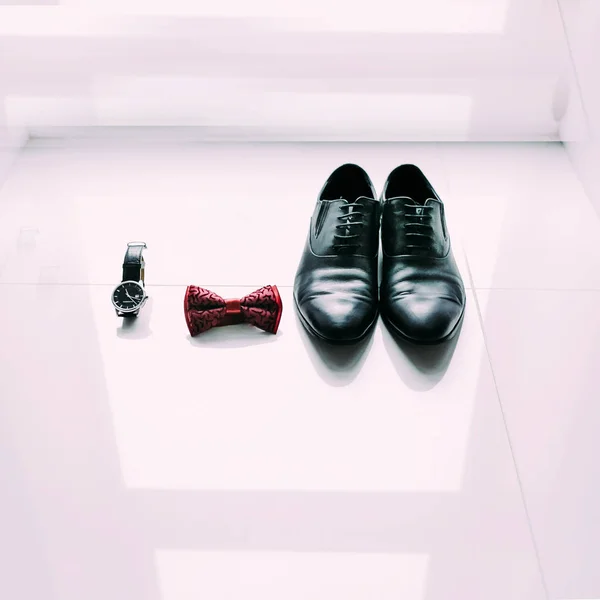 Grooms shoes, bow tie and watch on light window background — Stock Photo, Image