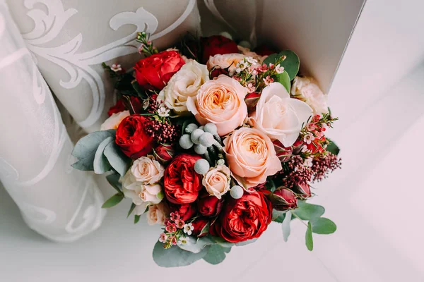 Vacker brudbukett röda blommor, rosa blommor och grönska stå bredvid fönstret — Stockfoto