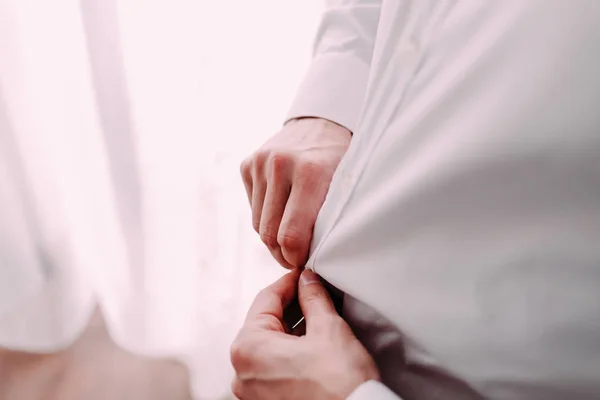 El hombre se prepara para el trabajo abotonando su camisa de negocios. Los novios preparación de la mañana antes de la boda —  Fotos de Stock