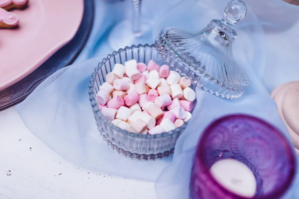 Bunte Mini-Marshmallows in Gläsern auf einem weißen Tisch mit blauer Spitze. verschiedene weiße und rosa Mini-Marshmallows. Marshmallow-Konzept. — Stockfoto