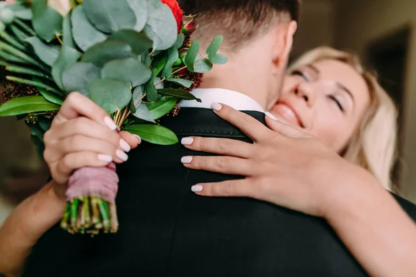 Immagine ravvicinata della sposa sorridente con un bouquet abbraccia il groo — Foto Stock