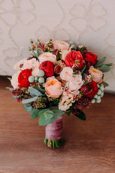 Hermoso ramo de boda de flores rojas, flores rosadas y verde de pie en el fondo de la pared —  Fotos de Stock