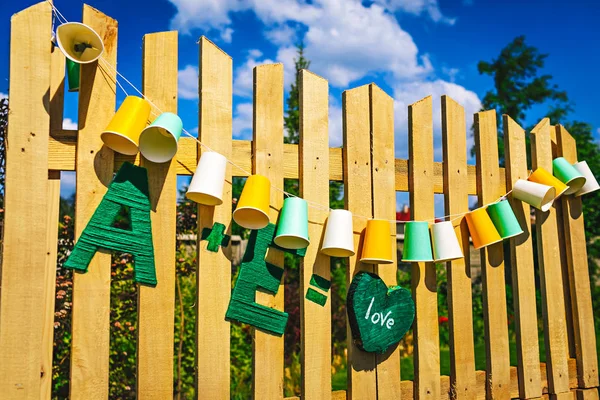 Garland spravedlivé žárovky. Svatba, párty dekorace. Girlanda z papírových kelímků visí na dřevěných desek. Detail — Stock fotografie