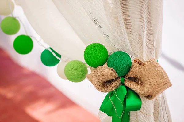 Guirlande de boules de coton accroché sur un rideau blanc. Décoration de couleur vive. Mariage — Photo