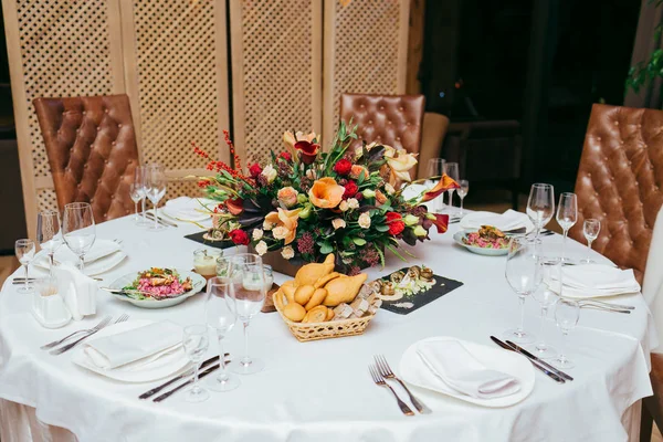 Festive table served with dishes and decorated with branches of greenery. Wedding banquet.