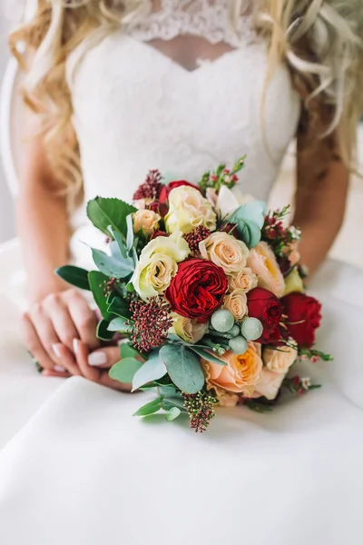 Braut hält einen Blumenstrauß in der Hand. wunderschöner Brautstrauß mit weißen und pfirsichfarbenen Rosen, roten Pfingstrosen und anderen Blumen. Hochzeitsmorgen. Nahaufnahme. — Stockfoto