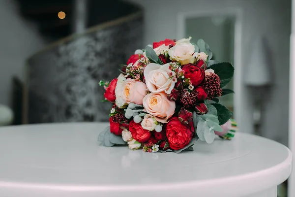 Hermoso ramo de novia con rosas blancas y melocotones, peonías rojas y otras flores en una mesa blanca. Primer plano —  Fotos de Stock