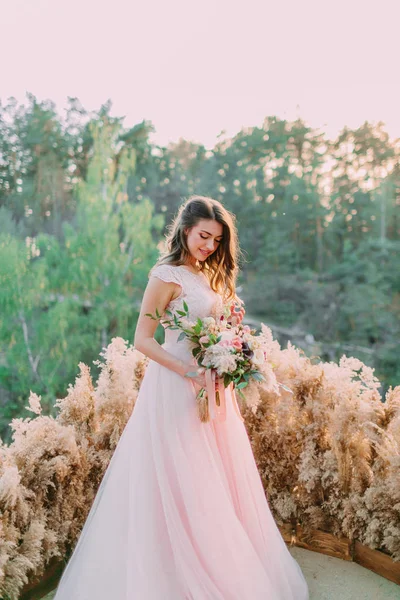 Brida con rustico bouquet de novia en la roca. Ceremonia de bodas, decoración — Foto de Stock