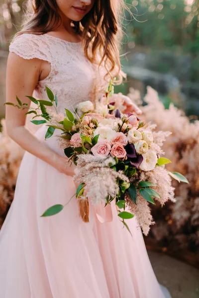 A bride holds rustic wedding bouquet consisting of different flowers. Decoration Artwork — Stock Photo, Image