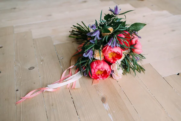 Rustic wedding bouquet with white roses, crimson peonies, and greens on a wooden floor. Close-up. — Stock Photo, Image