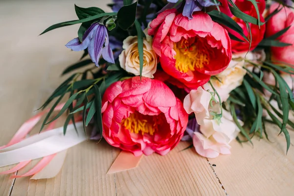 Rustikaler Hochzeitsstrauß mit weißen Rosen, purpurroten Pfingstrosen und Grüntönen auf einem Holzboden. Nahaufnahme. — Stockfoto