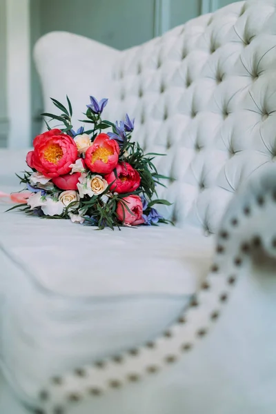 Rustic wedding bouquet with white roses and crimson peonies on a luxury cream sofa. Close-up. Side view — Stock Photo, Image