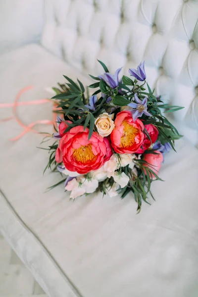 Rustikaler Hochzeitsstrauß mit weißen Rosen und karminroten Pfingstrosen auf einem luxuriösen cremefarbenen Sofa. Nahaufnahme. — Stockfoto