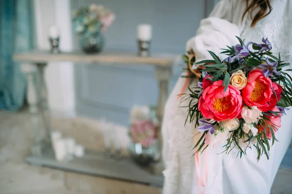 La mariée tient dans ses mains un bouquet de mariage rustique avec des roses blanches et des pivoines pourpres sur fond de fenêtre. Gros plan — Photo