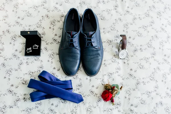 Bräutigam Schuhe und Manschettenknöpfe, blaue Krawatte, Armbanduhr, boutonniere auf hellem Hintergrund. Hochzeitskonzept. — Stockfoto