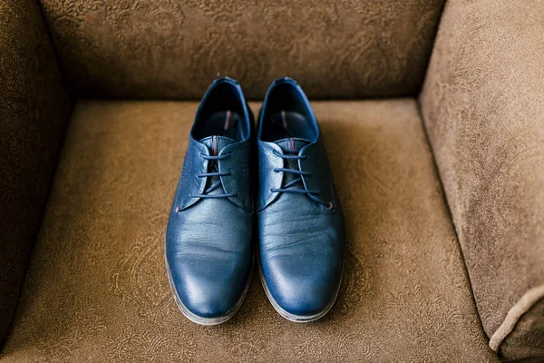 Damatlar mavi ayakkabılar üzerinde kahverengi bir koltuk. Düğün kavramı. Sanat, yumuşak odak — Stok fotoğraf