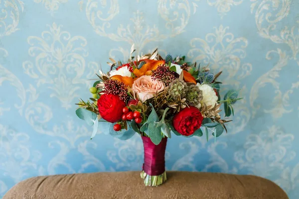 Blumenschmuck für eine Hochzeitsgesellschaft. der Strauß von rosa Rosen, roten Pfingstrosen und anderen Blumen auf blauem Hintergrund. Hochzeit. Kunstwerk — Stockfoto