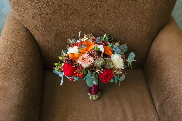 Flower arrangement for a wedding party. The bouquet of pink roses, red peonies and other flowers on brown armchair. Wedding. Artwork. Soft focus — Stock Photo, Image