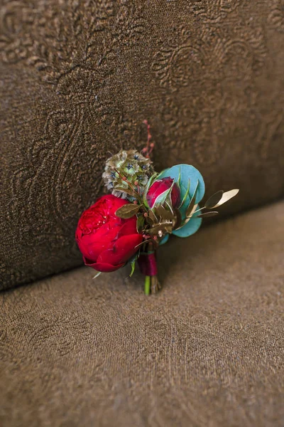 Damat yaka ile kahverengi bir arka plan üzerinde kırmızı bir Şakayık çiçeği. Düğün kavramı — Stok fotoğraf