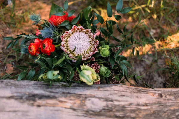A rustic wedding bouquet with pink ribbons near the log. Artwork — Stock Photo, Image