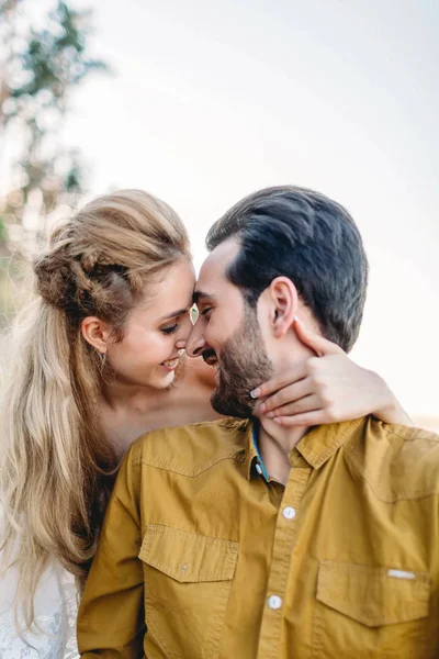 Un jeune couple sourit et touche le front. Cérémonie de mariage d'automne à l'extérieur. Mariés et mariés se regardent avec tendresse et amour. Gros plan portrait — Photo