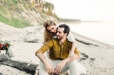 Genç bir çift eğleniyor ve sahilde sarılma. Güzel kız sevgilisini arkadan kucaklamak. Düğün yürüyüş. Bir yeni evliler birbirlerine benziyor. Sanat