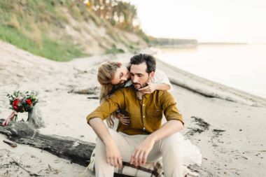 Genç bir çift eğleniyor ve sahilde sarılma. Güzel kız sevgilisini arkadan kucaklamak. Düğün yürüyüş. Bir yeni evliler birbirlerine benziyor. Sanat