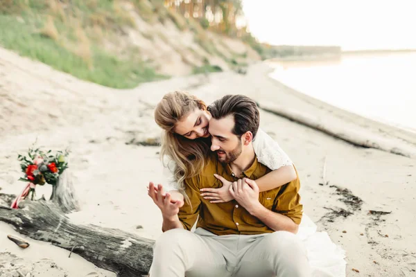Genç bir çift sahilde sarılıyor. Güzel kız sevgilisini arkadan kucaklamak. Düğün yürüyüş. Bir yeni evliler birbirlerine benziyor. Sanat