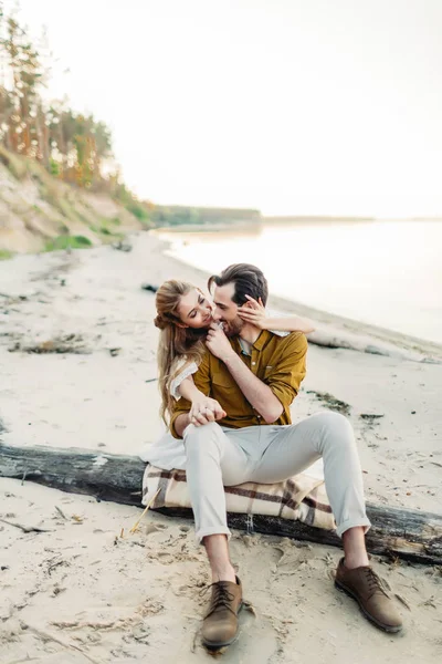Un jeune couple s'amuse et s'étreint sur la plage. Belle fille embrasser son petit ami de dos. Marche de mariage. Les jeunes mariés se regardent. Oeuvres — Photo