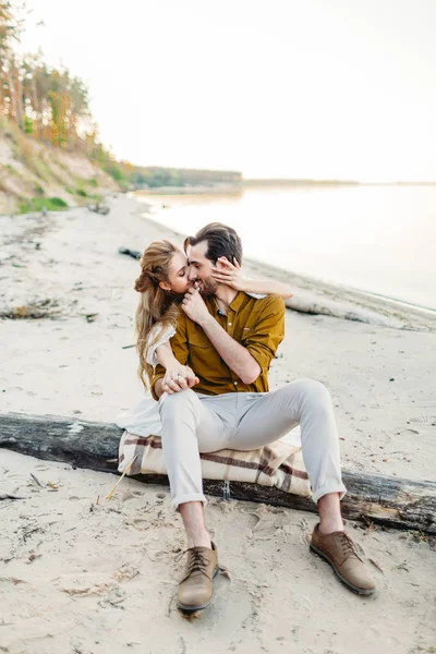 En stund innan en kyss. Ungt par är att ha kul och kramas på stranden. Vacker flicka omfamna sin pojkvän bakifrån. Bröllop promenad. En nygifta ser på varandra. Konstverk — Stockfoto