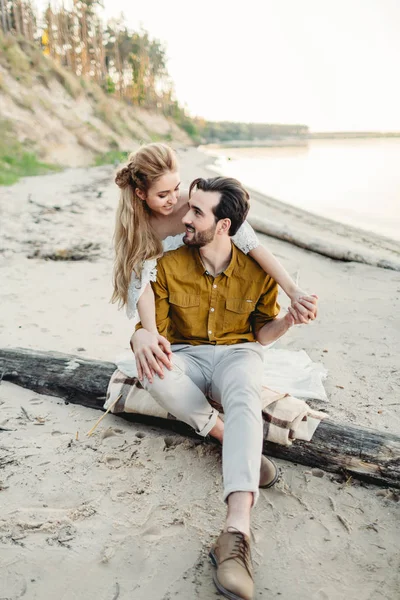 Un jeune couple s'amuse et s'étreint sur la plage. Belle fille embrasser son petit ami de dos. Marche de mariage. Les jeunes mariés se regardent. Oeuvres — Photo