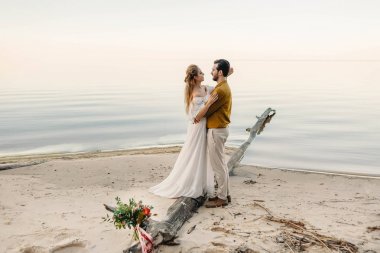 Güzel bir çift deniz arka plan üzerinde benimsemiş. An önce öpücük. Sahilde romantik tarih. Düğün. Sanat