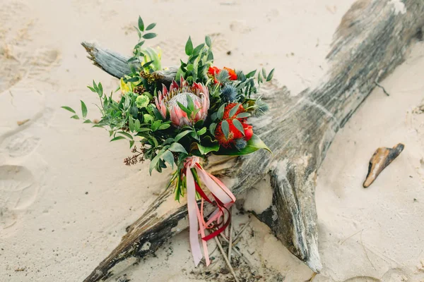 Rústico buquê de casamento com fitas cor de rosa no tronco, na praia. Close-up. Obra de arte, grão — Fotografia de Stock