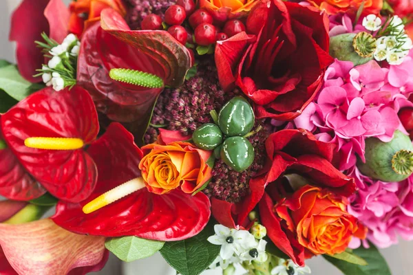 Stylové svatební kytice s oranžovou, crimson a bordeaux růží, máku a další květiny a zelené na dřevěné pozadí. Detail. — Stock fotografie