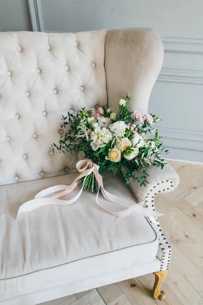 Rústico buquê de casamento com rosas cremosas e cravos brancos em um sofá creme de luxo. Close-up. Vista lateral — Fotografia de Stock